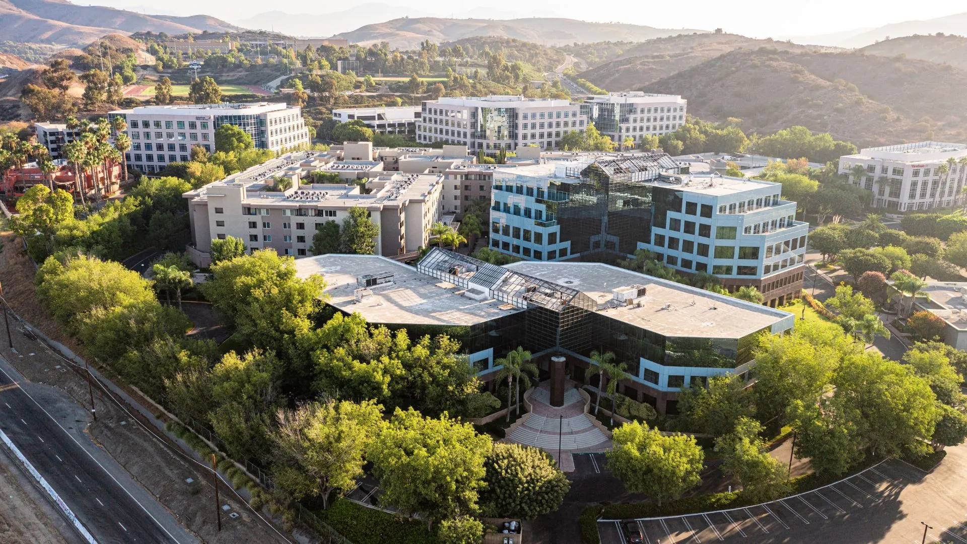 Aerial view looking down on an office campus set against hills